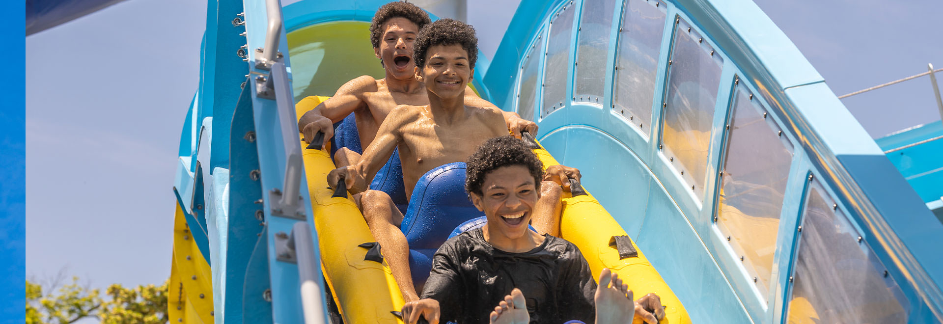 Three kids riding the Rocket Blast water ride